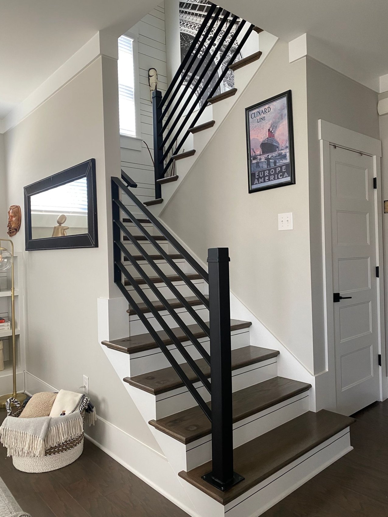 A staircase with a railing and a compact lower landing