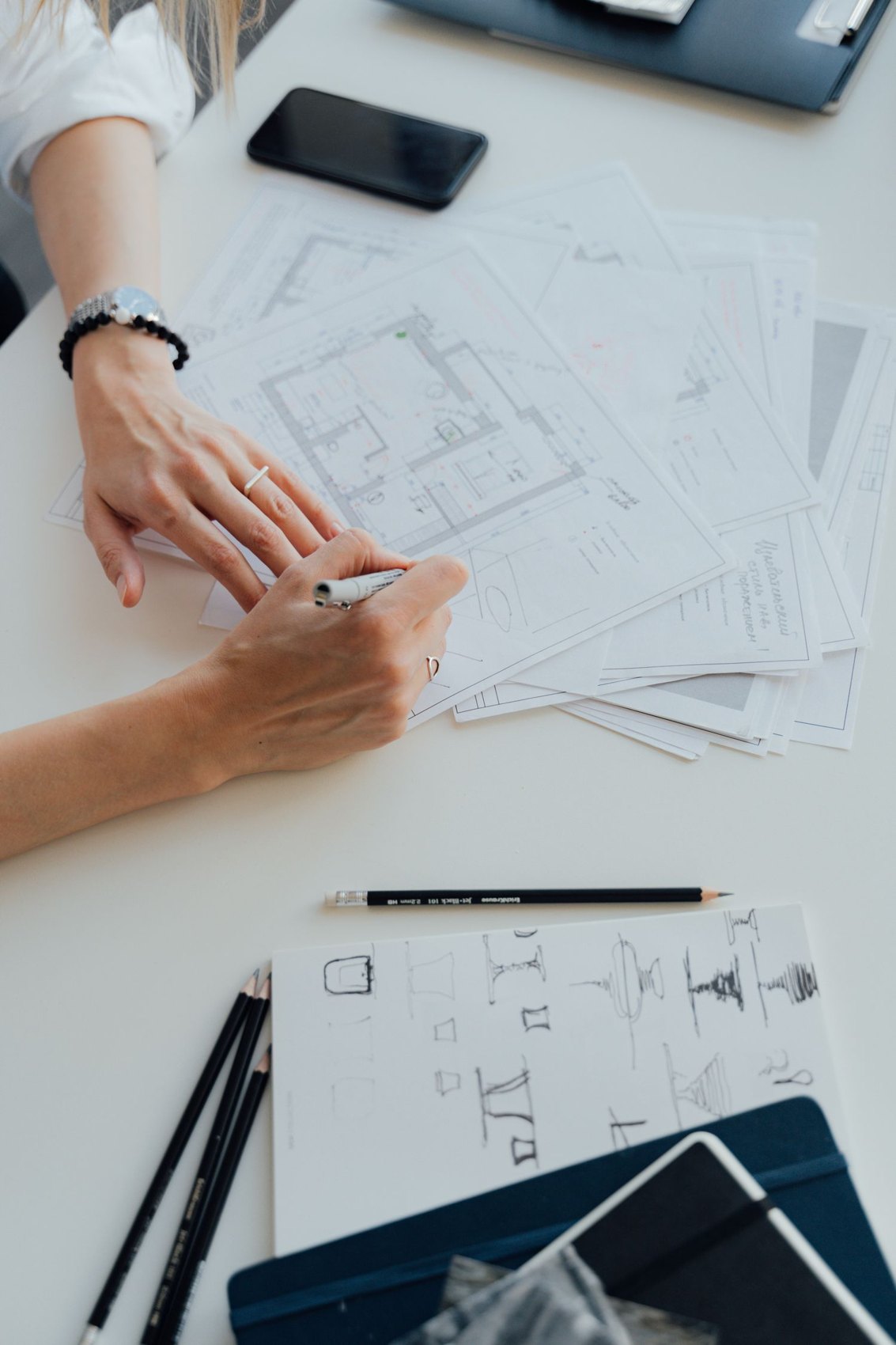 Hands drawing on a floor plan