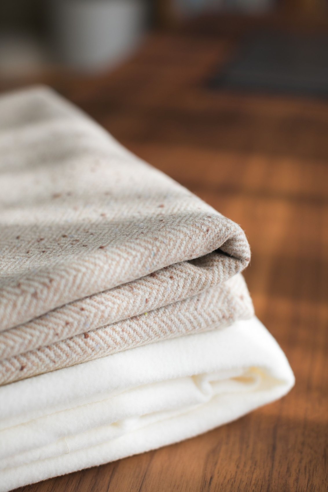 Folded pale textiles on a wooden floor