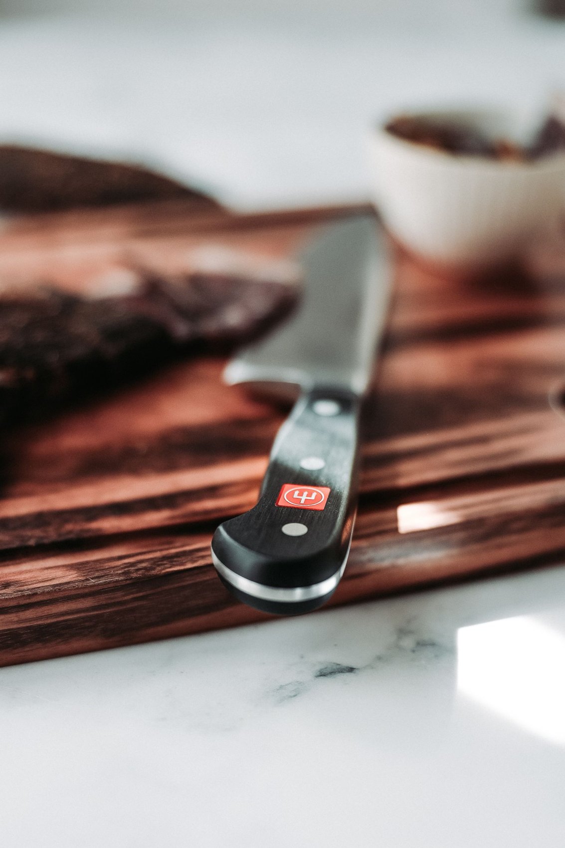 A kitchen knife resting on a chopping board