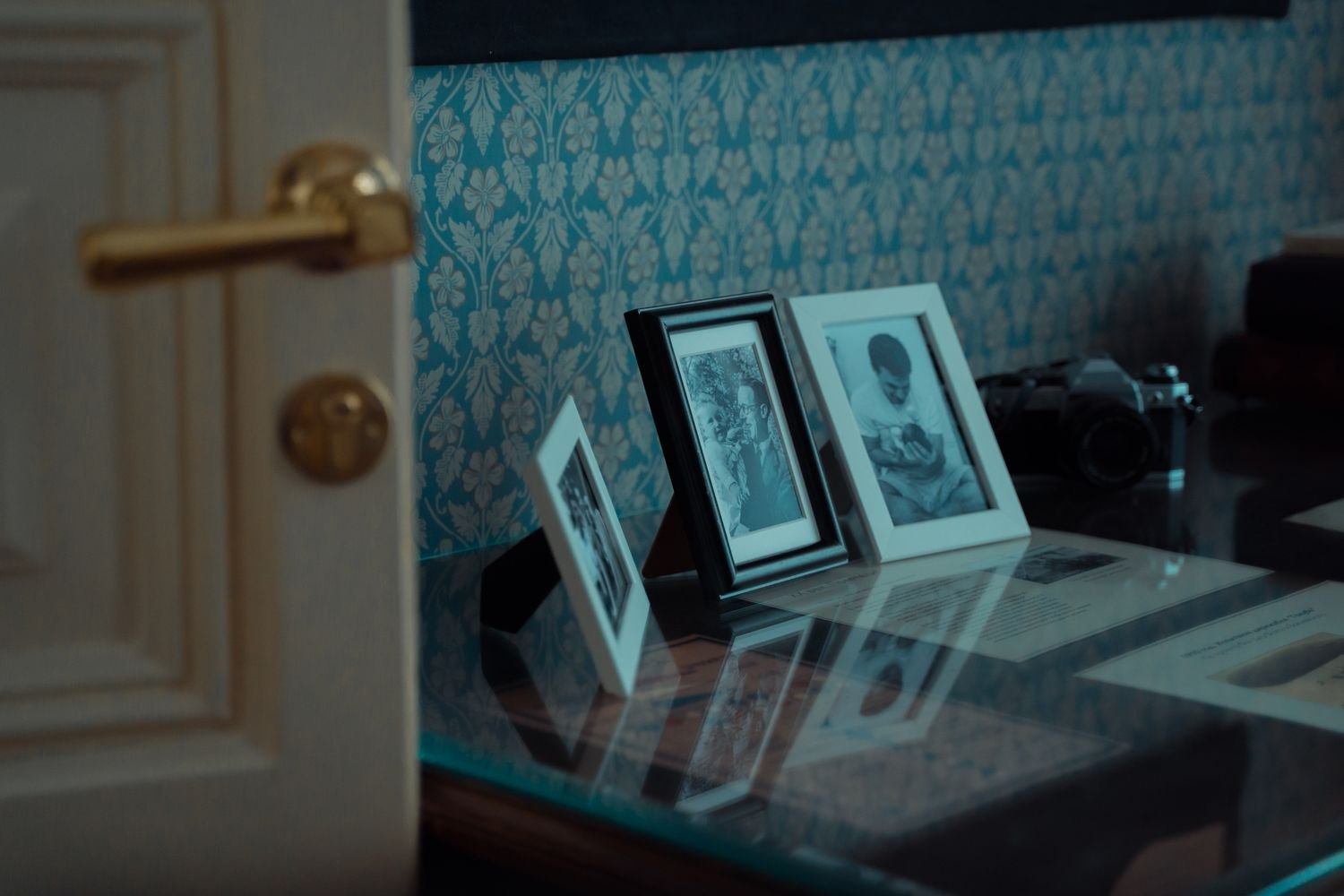 Framed photographs standing on a glass surface