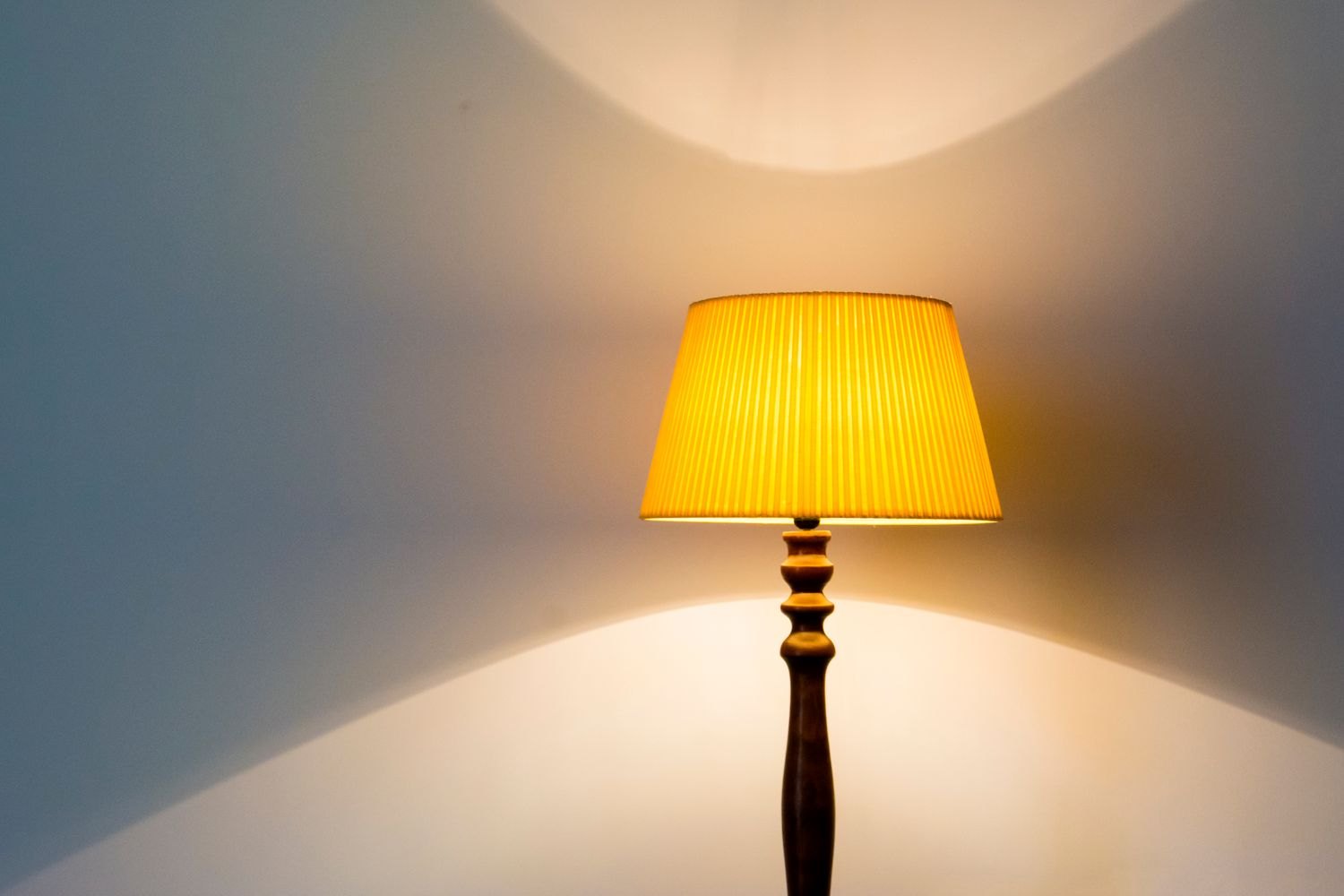 A lit table lamp with a yellow shade