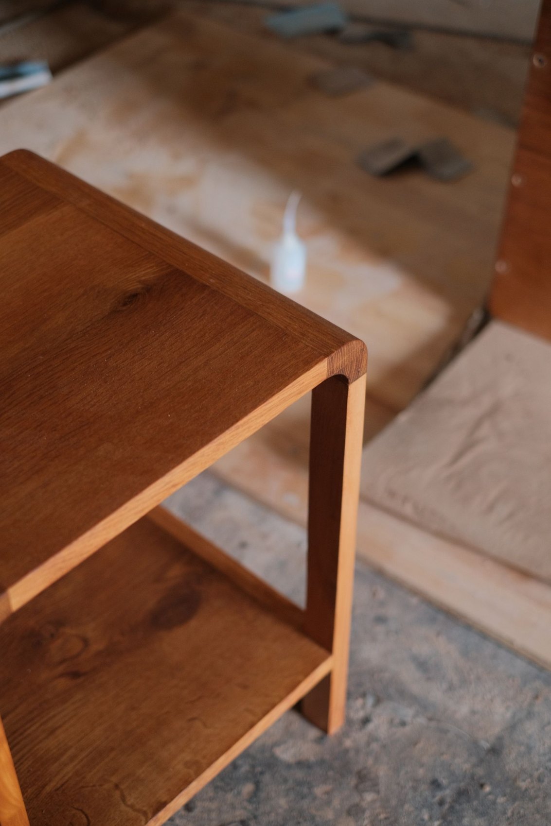 A small wooden shelving unit in a workshop