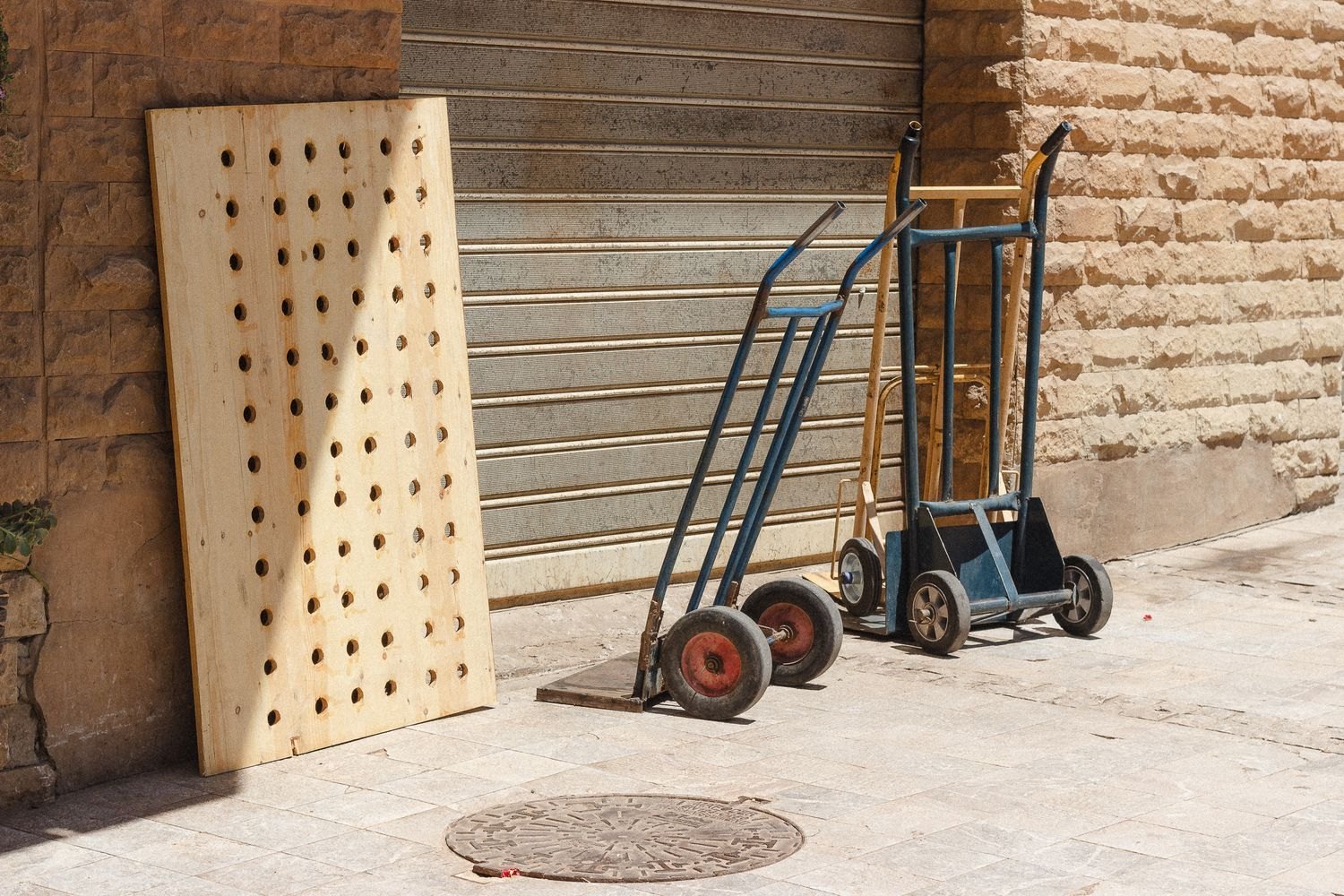 Hand trucks beside a wooden wall panel