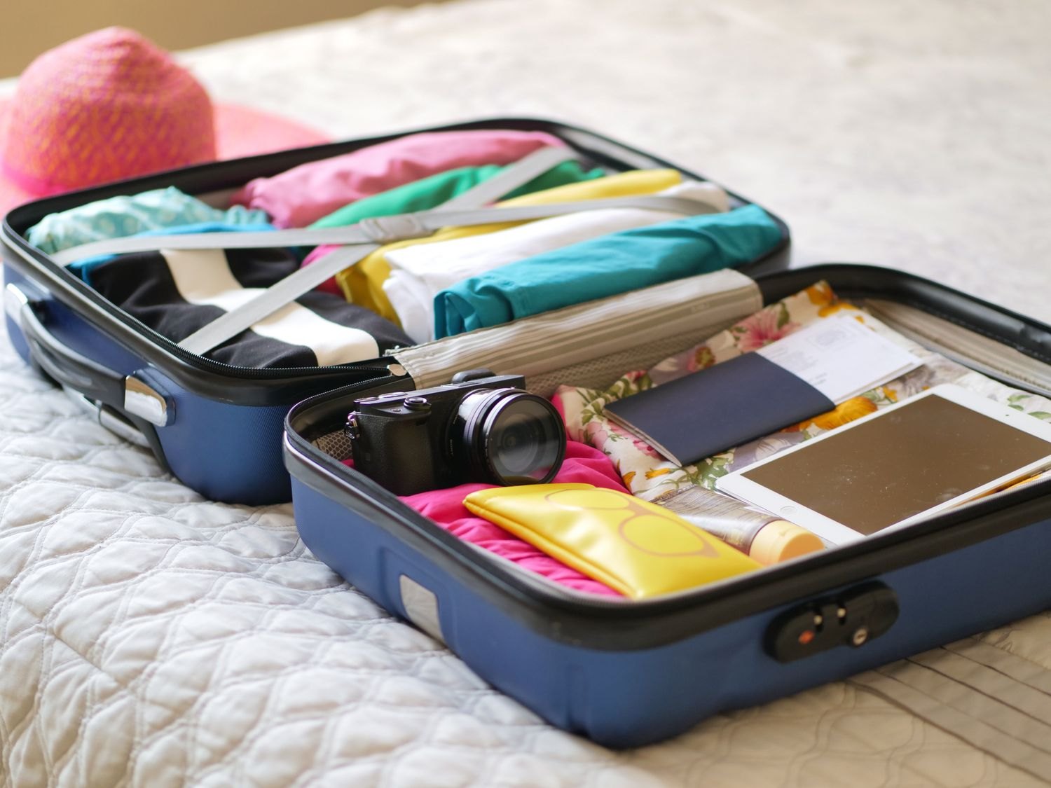 An open suitcase containing clothes and organised travel items