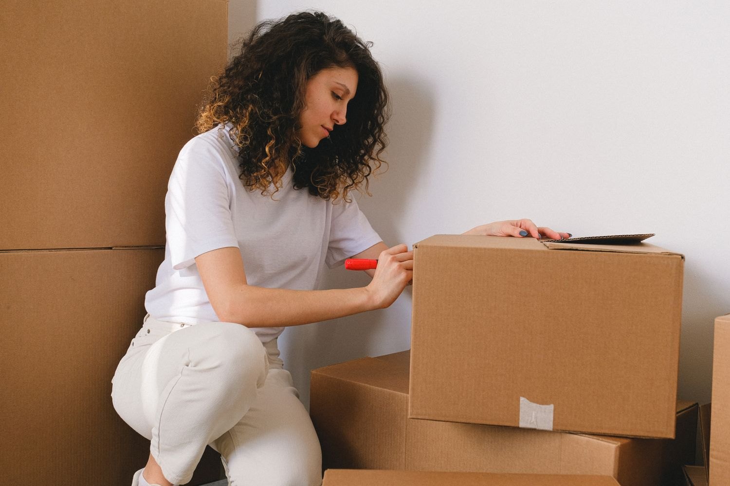 A woman labelling boxes while organising belongings