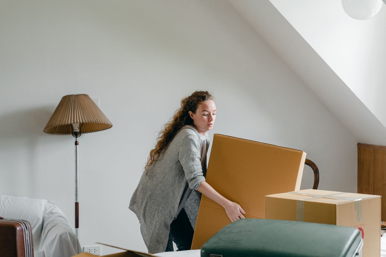 A woman lifting a large moving box