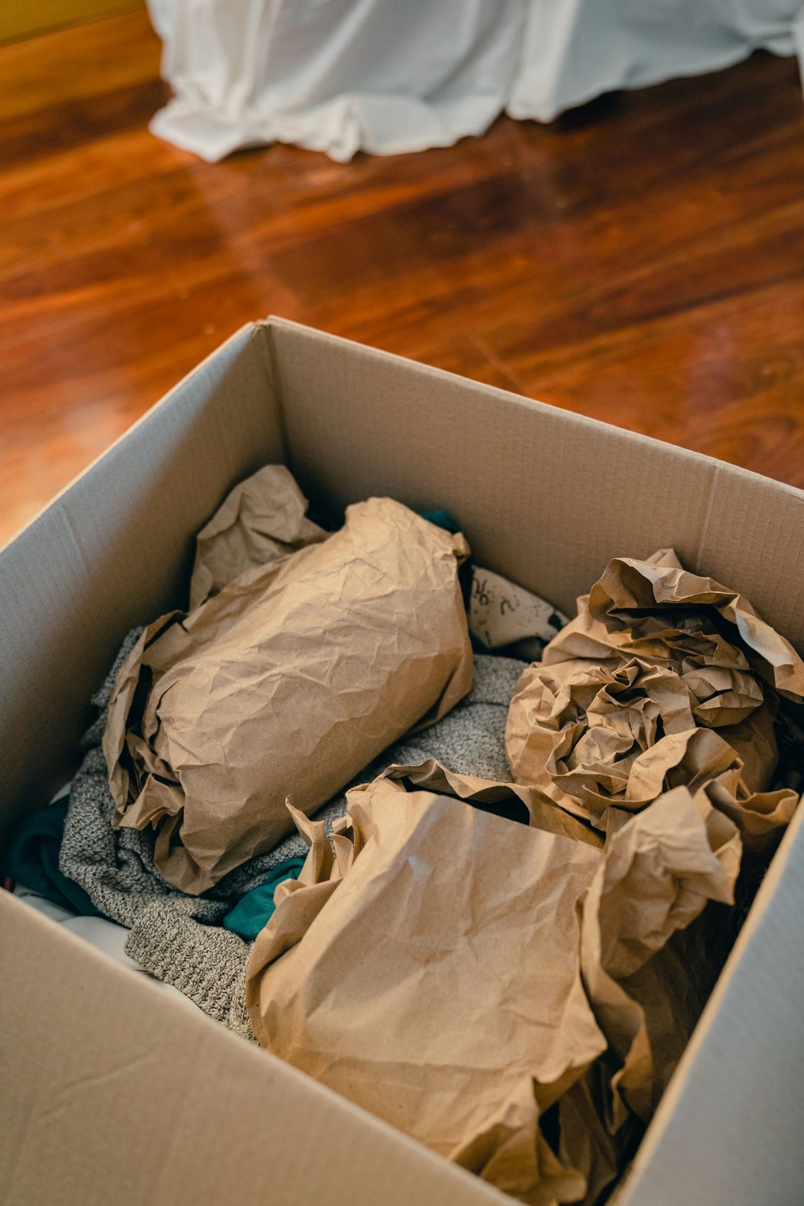 Objects protected with packing paper in a cardboard box