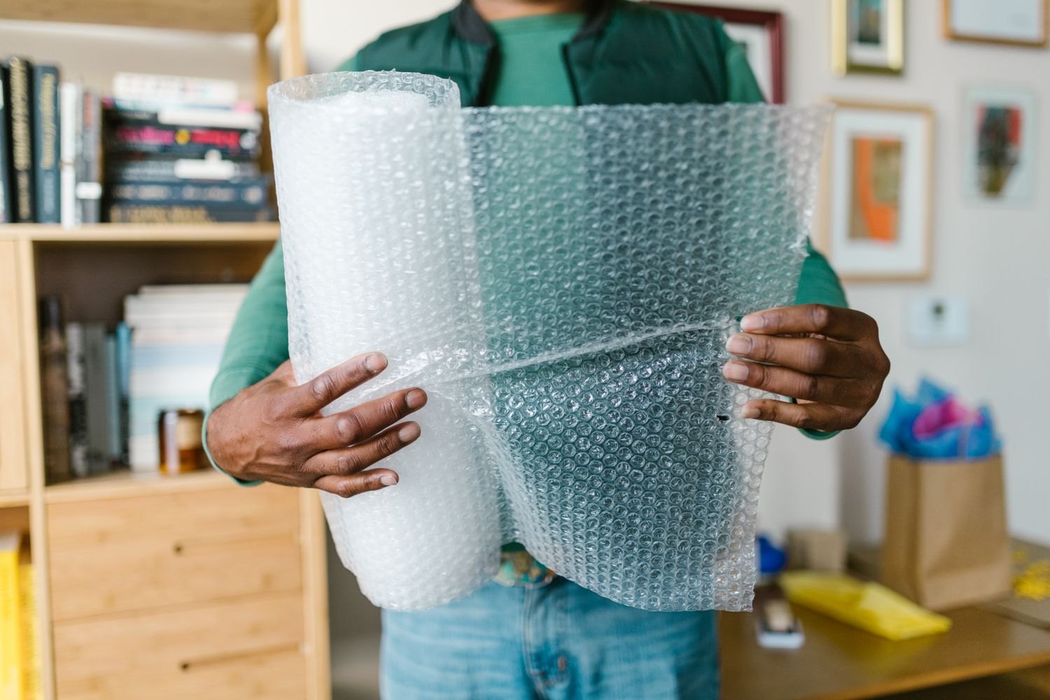 A person holding a roll of bubble wrap