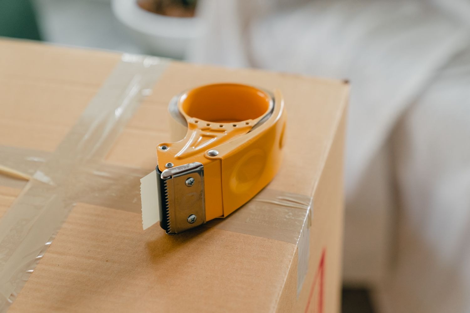 A packing tape dispenser on a sealed box