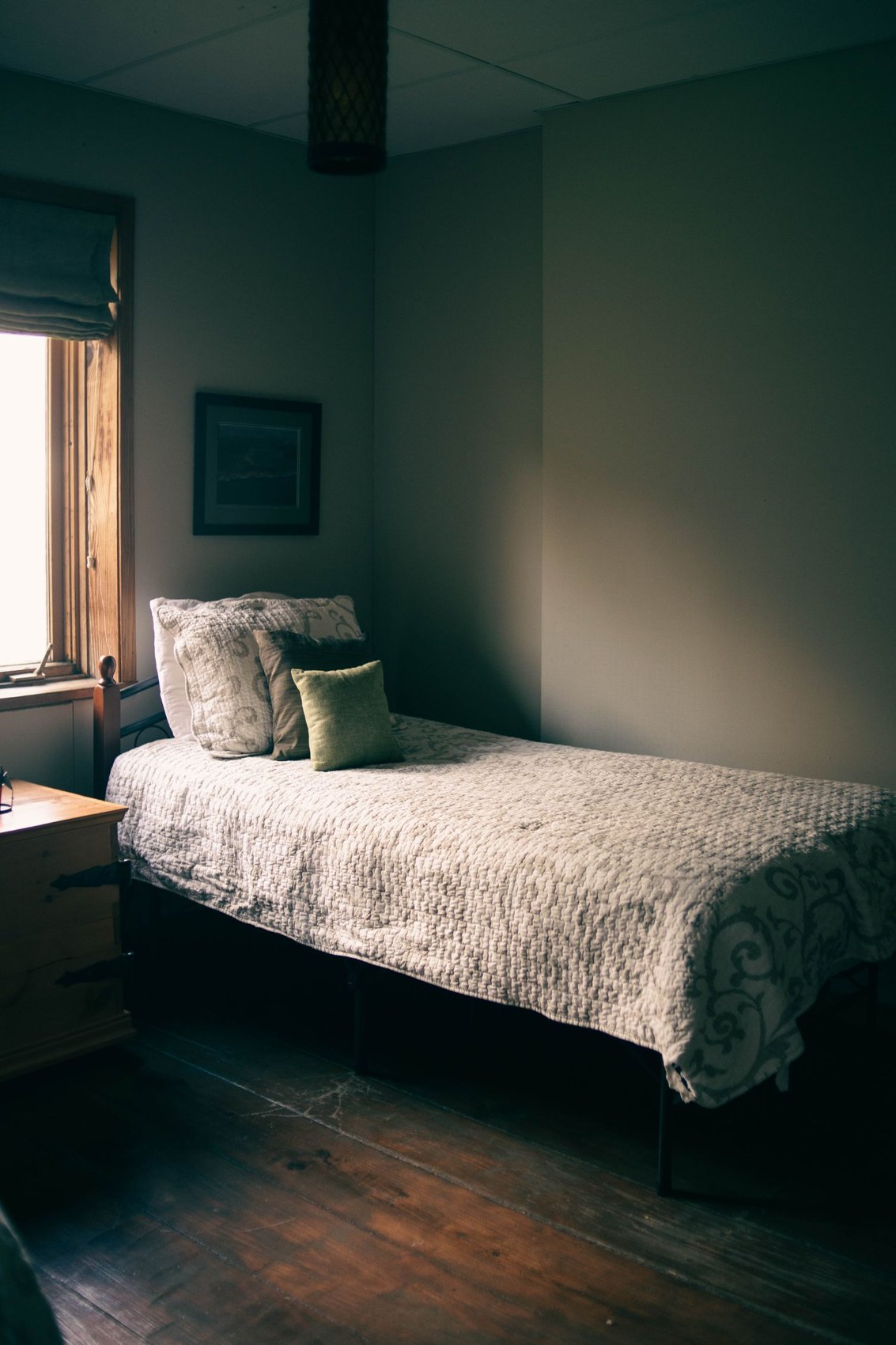A simply furnished sleeping space with a single bed