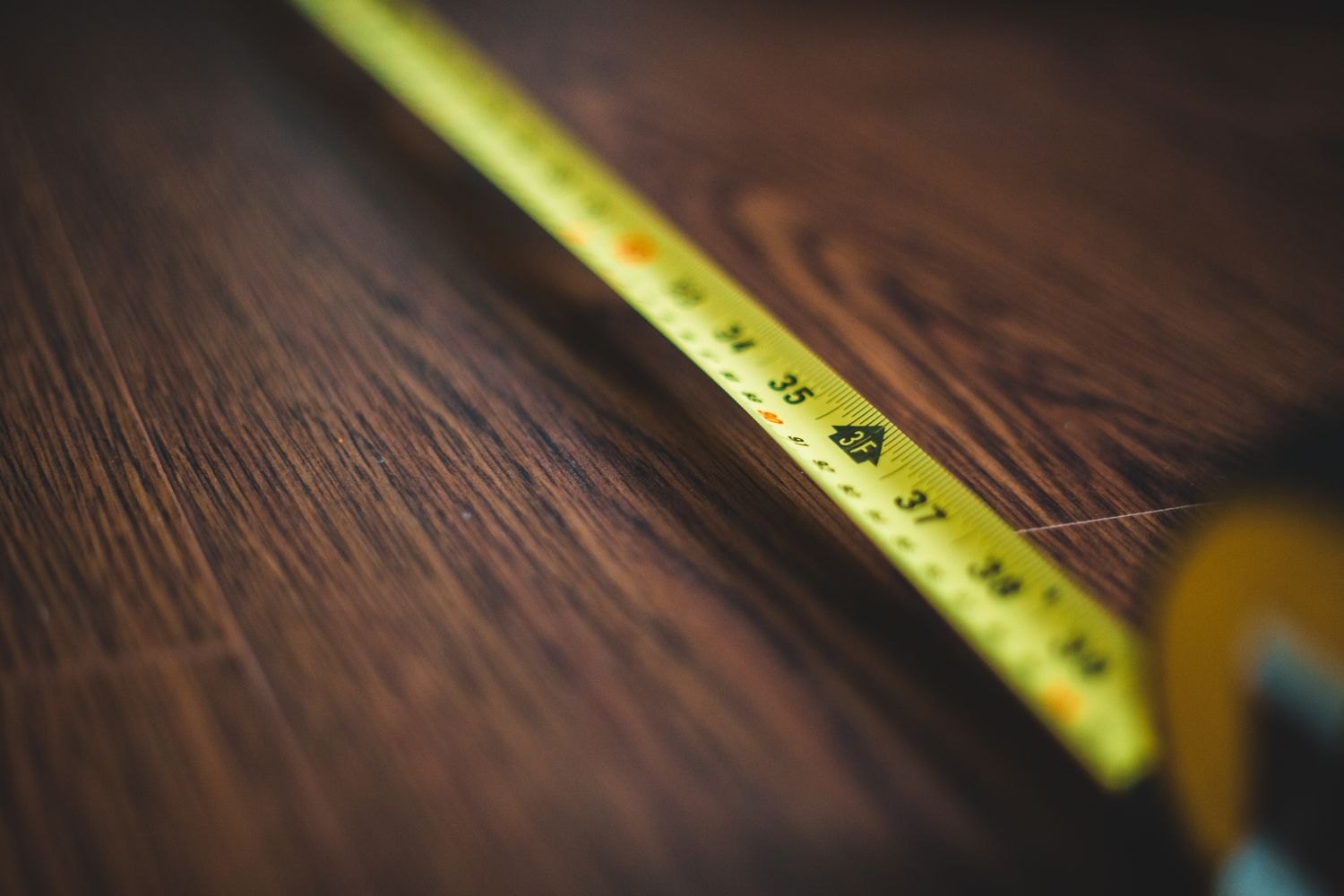 An extended tape measure on a wooden floor