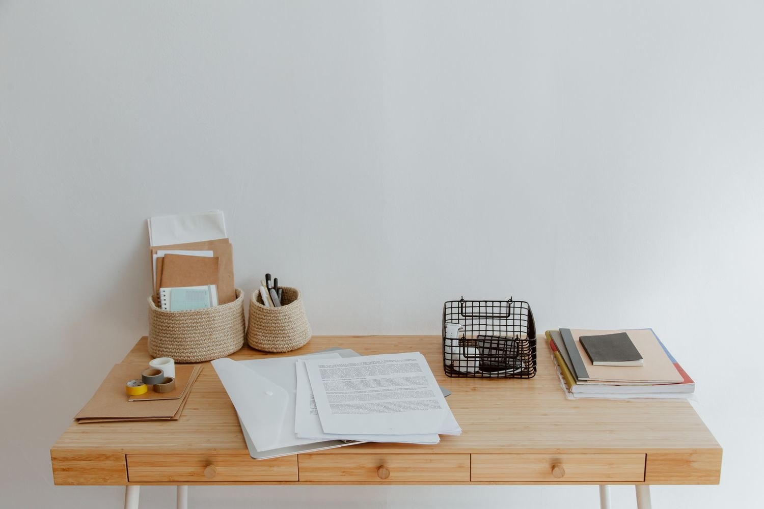 A small desk with paper trays and writing supplies