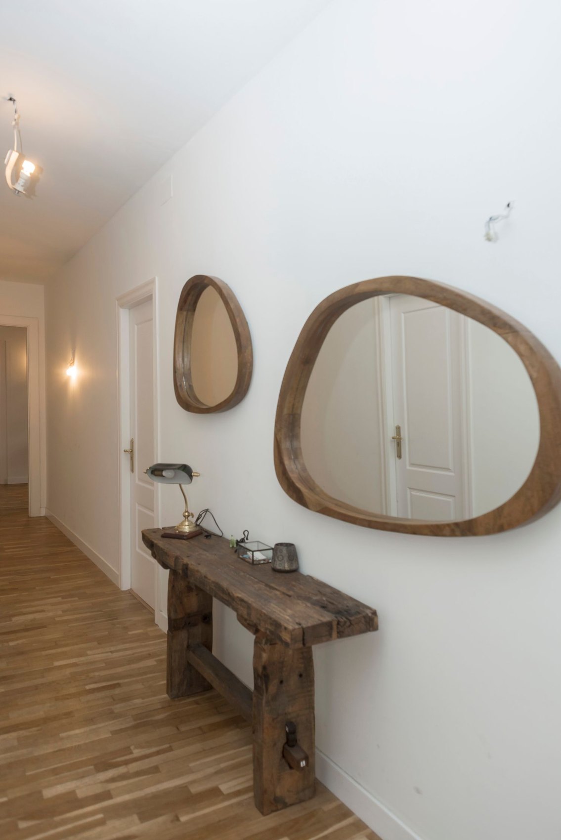 A narrow console table and mirror in an entrance hall