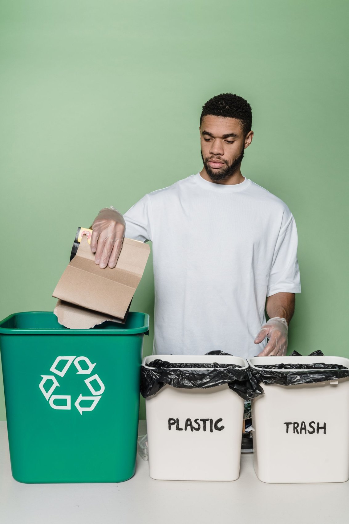 A man sorting cardboard into a recycling bin
