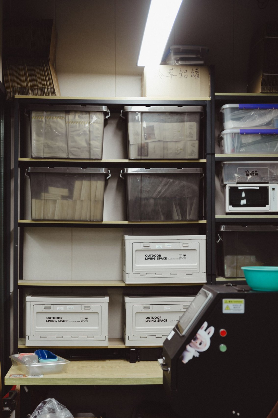 Labelled containers on shelves in a storage room